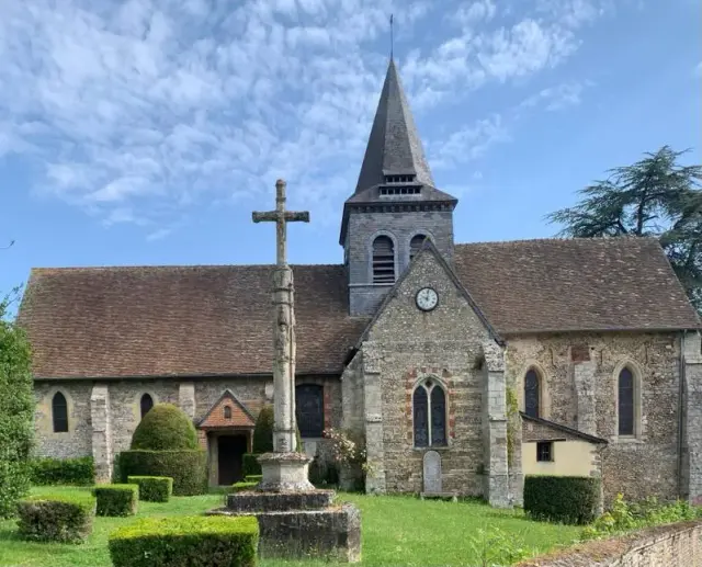 L'église de Saint-Denis-le-Ferment et son calvaire de pierre, sous un ciel d'été.