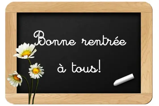 Ardoise encadrée de bois portant l'inscription manuscrite « Bonne rentrée à tous ! », ornée de marguerites blanches et d'un morceau de craie.