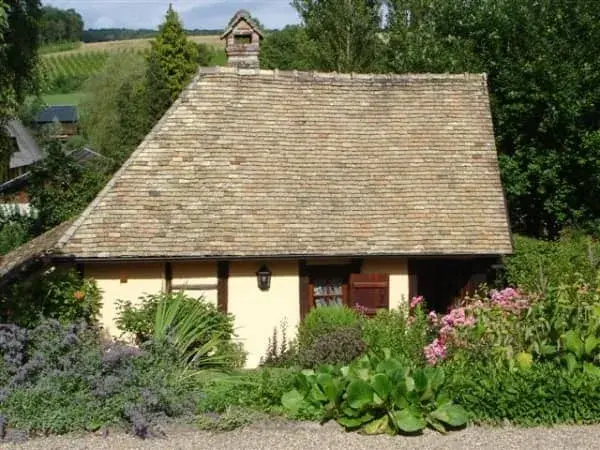 Petit bâtiment au toit de chaume entouré de verdure