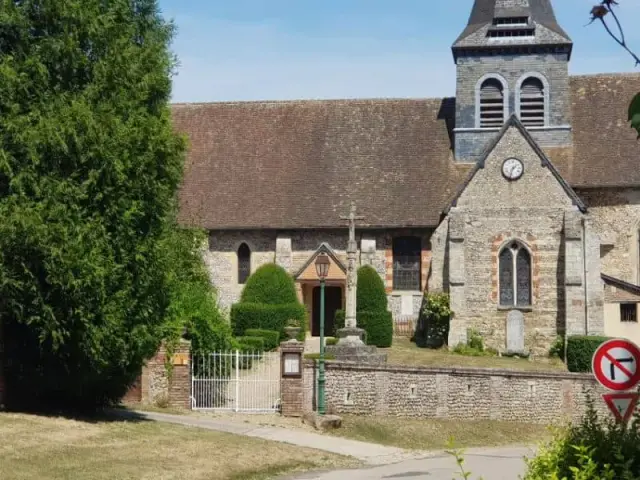 Bâtiment ancien avec clocheton derrière un portail
