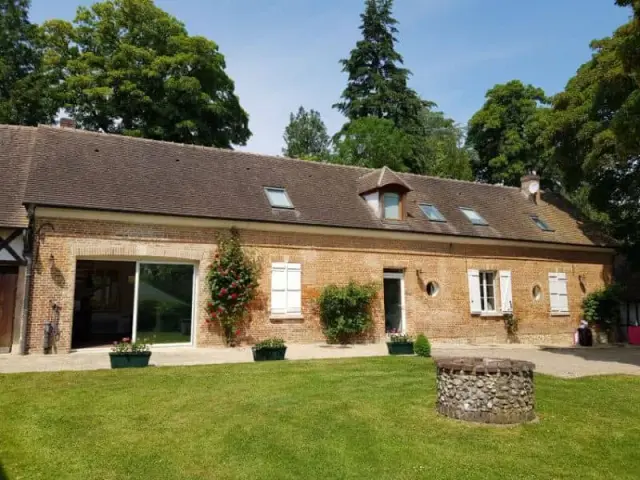 Bâtiment bas en brique avec personnes devant