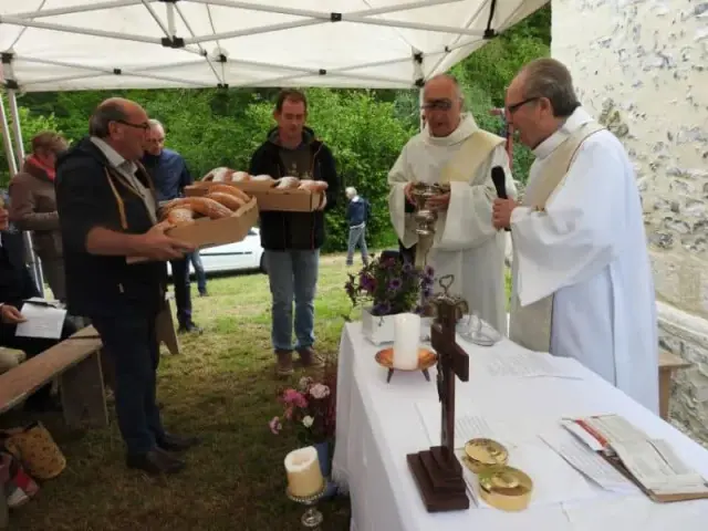 Personnes en robe claire et croix lors d'une cérémonie