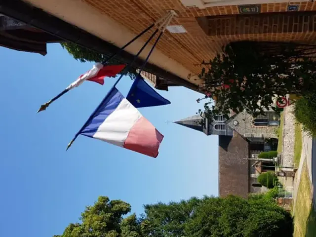 Drapeau français devant une façade en brique