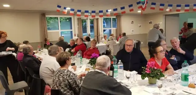 Salle décorée aux couleurs tricolores, personnes attablées