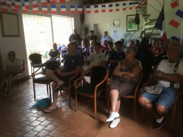 Personnes assises le long d'un mur en pierre