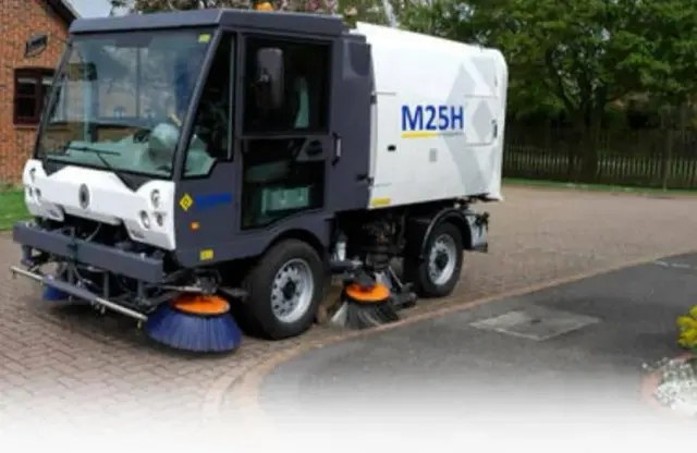 Camion-balayeuse de voirie dans une rue