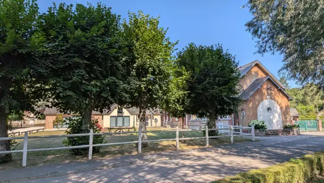 Allée bordée d'une clôture blanche devant une bâtisse ancienne